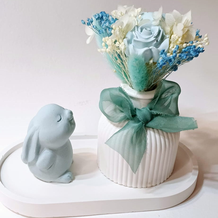 Base e coelhinho de gesso com jarra e flores