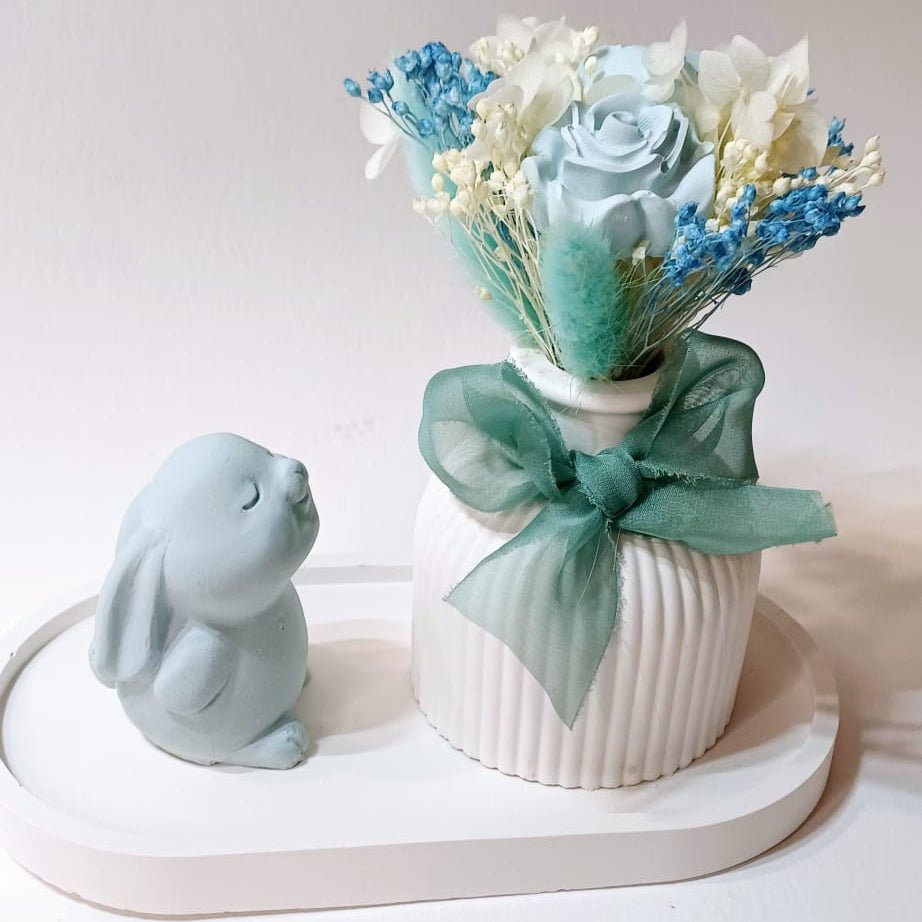 Base e coelhinho de gesso com jarra e flores